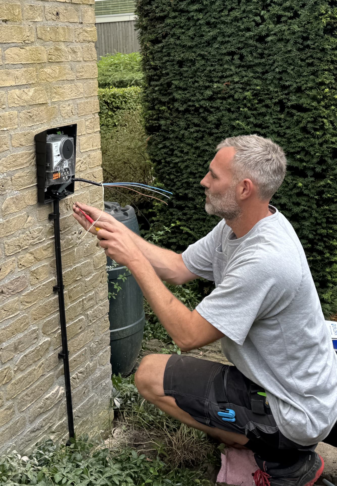 Arjan van Aik sluit bedrading aan bij een elektrische installatie